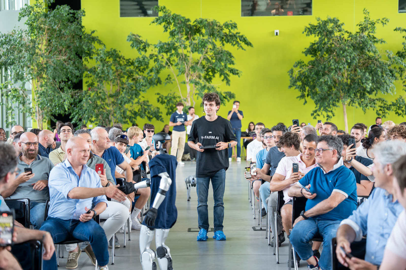 Robot umanoide cammina tra il pubblico che lo filma con gli smartphone